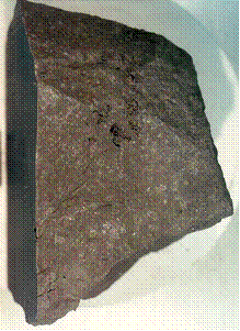 Close-up of surface of 70125,261 showing zap pits, and apparent vugs.  Sample is about 12 cm long.