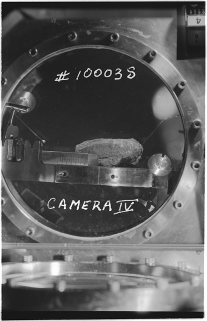 Black and white photograph of Apollo 11 Sample(s) 10003; Processing photograph displaying sample in vaccum vault with camera IV.