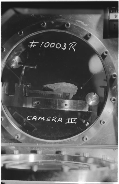 Black and white photograph of Apollo 11 Sample(s) 10003; Processing photograph displaying sample in vaccum vault with camera IV.