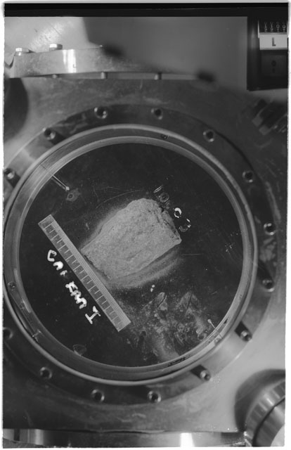 Black and white photograph of Apollo 11 Sample(s) 10003; Processing photograph displaying sample in vaccum vault with camera I.