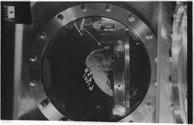 Black and white photograph of apollo 11 Sample(s) 10019; Processing photograph displaying sample in vacuum vault at R5P.
