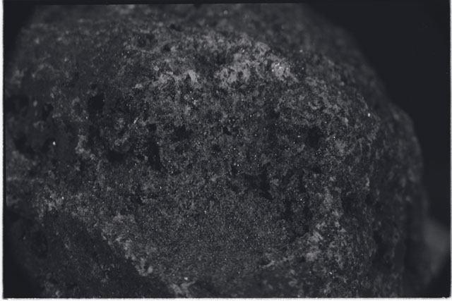 Black and white photograph of Apollo 11 Sample(s) 10050; Processing photograph displaying close up of surface area.