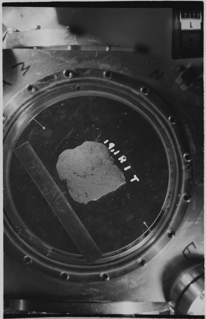 Black and white photograph of apollo 11 Sample(s) 10019; Processing photograph displaying sample in vacuum vault at R1T.