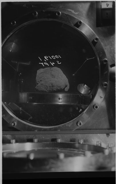 Black and white photograph of apollo 11 Sample(s) 10019,1; Processing photograph displaying sample in vacuum vault at S4PT.