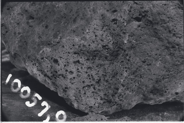 Black and white photograph of Apollo 11 Sample(s) 10057,0; Processing photograph displaying close up of surface.