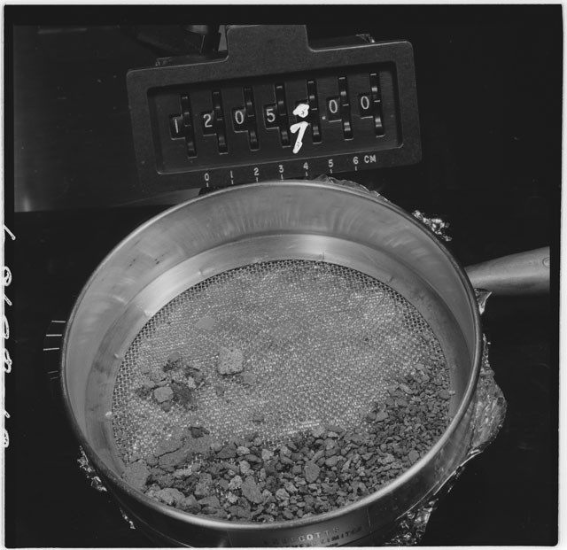 Black and white photograph of Apollo 12 Sample(S) 12057; Processing photograph displaying an sieving of rake samples.