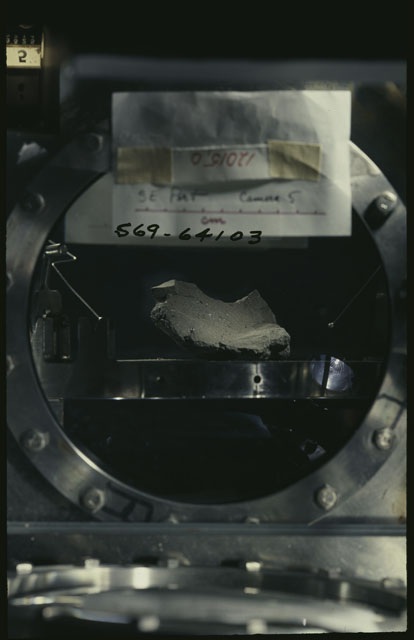 Color photograph of Apollo 12 Sample(S) 12015; Processing photograph displaying the sample using Camera V .