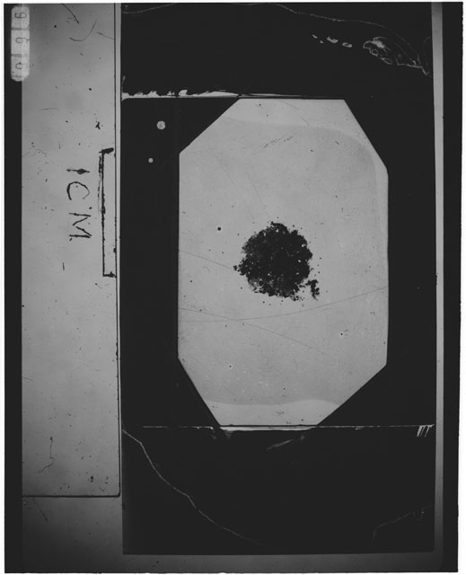 Black and white photograph of Apollo 12 sample 12001,112; Thin Section photograph displaying grain mount.