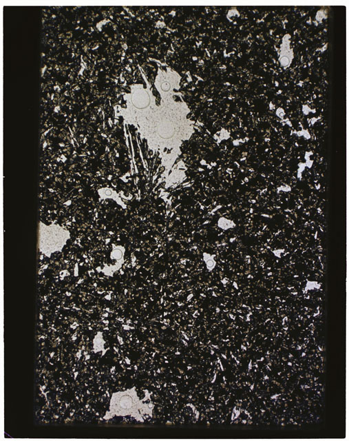 Color photograph of Apollo 11 Sample(s) 10049; Thin Section b photograph using transmitted light.