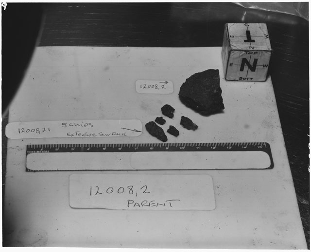 Black and white photograph of Apollo 12 Sample(S) 12008,2,21; Processing photograph displaying a post chip sample with an orientation of N,T.
