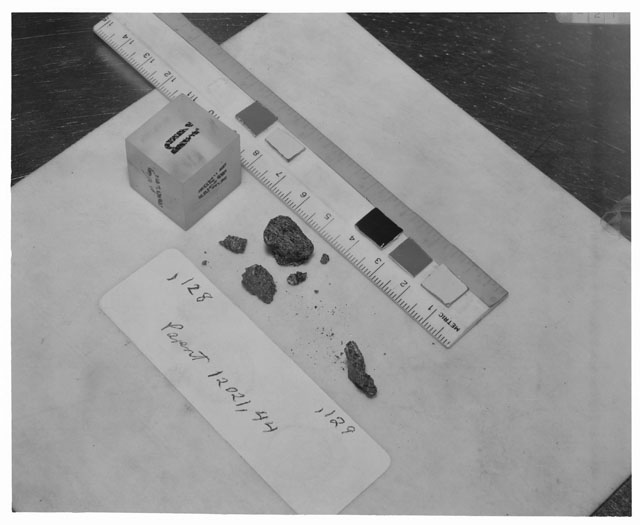 Black and white photograph of Apollo 12 Sample(S) 12021,128,129; Processing photograph displaying a chips and fines group with an orientation of N,W,B.