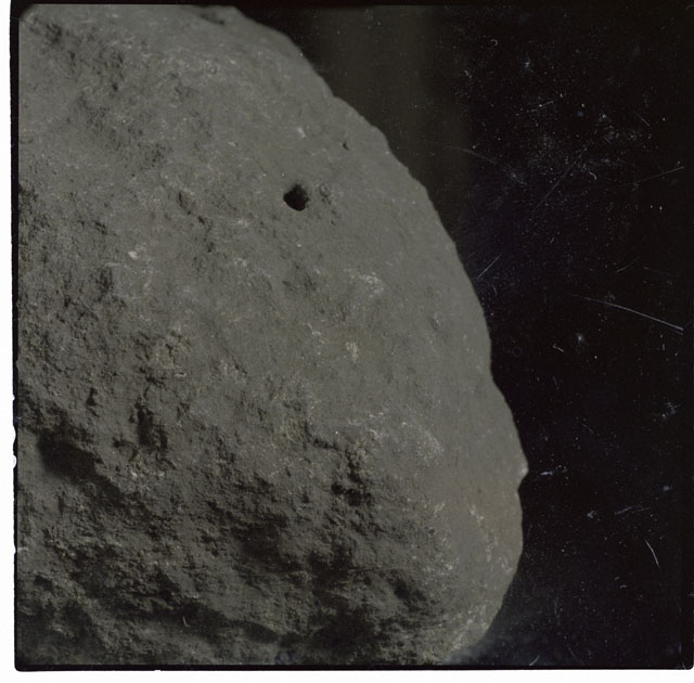 Color photograph of Apollo 12 sample 12002; Processing mosaic photograph displaying a close up of the surface.
