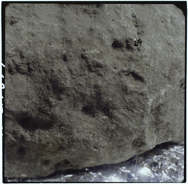 Color photograph of Apollo 12 sample 12002; Processing mosaic photograph displaying a close up of the surface.