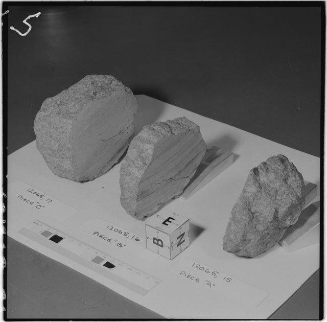 Black and white photograph of Apollo 12 Sample(S) 12065,15-17; Processing photograph displaying a slab reconstruction sample with an orientation of E,B,N.