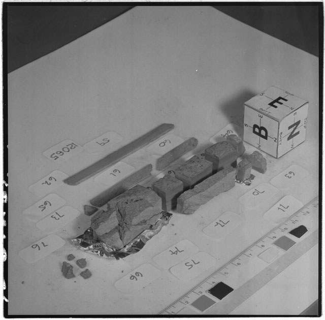 Black and white photograph of Apollo 12 Sample(S) 12065,59-71,73-76; Processing photograph displaying a slab reconstruction sample with an orientation of E,B,N.