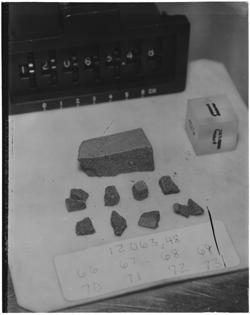 Black and white photograph of Apollo 12 Sample(S) 12063,48,66-73; Processing photograph displaying a post chip with an orientation of E,N,B.