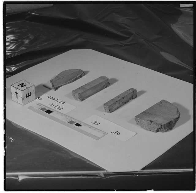 Black and white photograph of Apollo 12 Sample(S) 12063,28,30-34; Processing photograph displaying a slab group with an orientation of N,T,E.