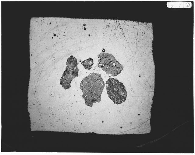 Black and white photograph of Apollo 12 sample 12030,20; Thin Section photograph displaying grain mount.