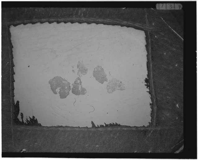 Black and white photograph of Apollo 12 sample 12001,104; Thin Section photograph displaying grain mount.