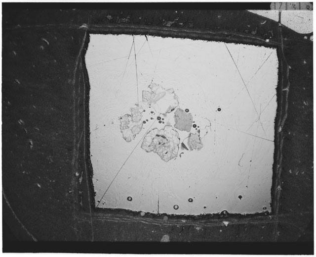 Black and white photograph of Apollo 12 sample 12033,84; Thin Section photograph displaying grain mount.