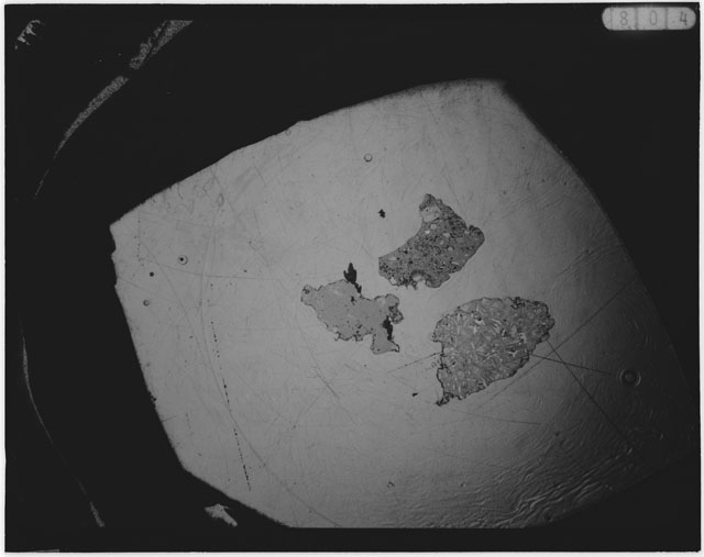 Black and white photograph of Apollo 12 sample 12001,108; Thin Section photograph displaying grain mount.