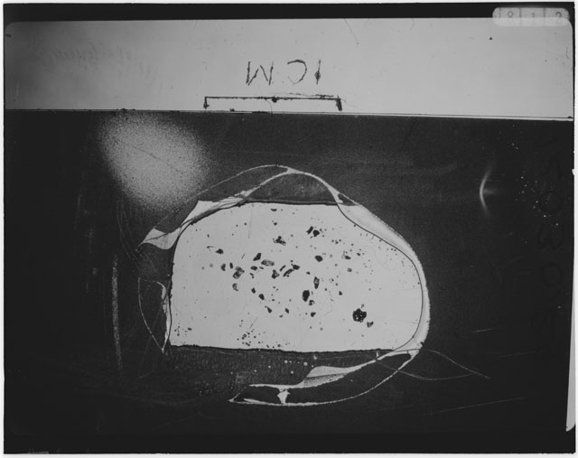 Black and white photograph of Apollo 12 sample 12030,24; Thin Section photograph displaying grain mount.