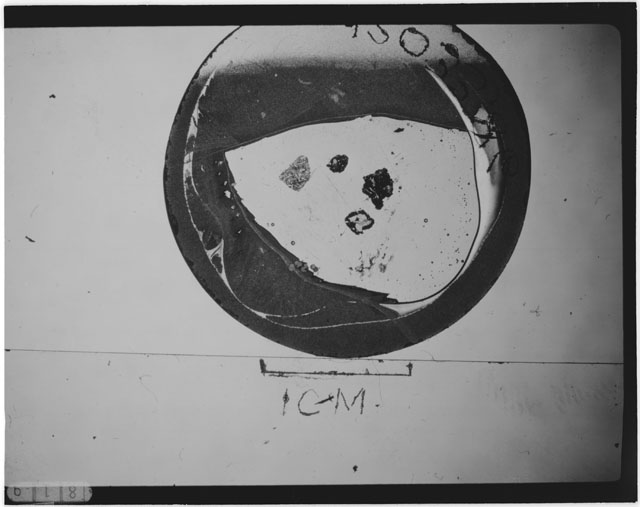 Black and white photograph of Apollo 12 sample 12033,86; Thin Section photograph displaying grain mount.
