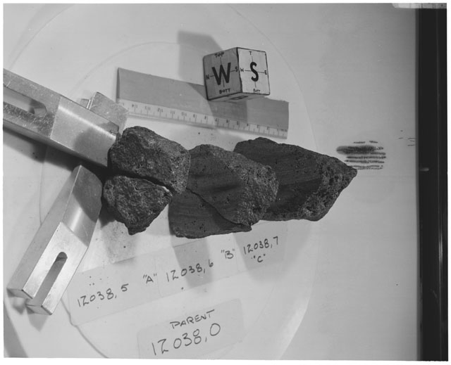 Black and white photograph of Apollo 12 Sample(S) 12038,5-7; Processing photograph displaying a post cut sample with an orientation of W,S.