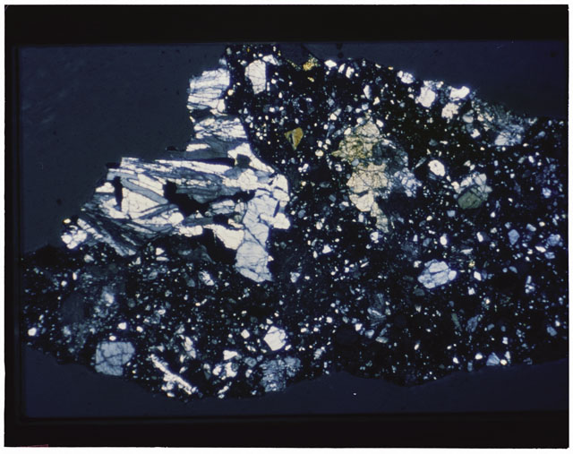 Color photograph of Apollo 12 sample 12030,22; Thin Section photograph displaying grain mount using transmitted light.