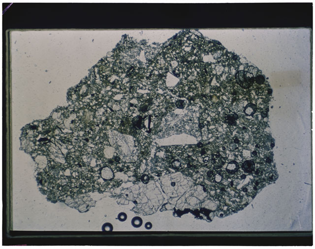 Color photograph of Apollo 12 sample 12030,22; Thin Section photograph displaying grain mount using transmitted light.
