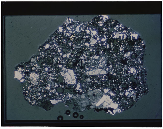 Color photograph of Apollo 12 sample 12030,22; Thin Section photograph displaying grain mount using cross nichols light.