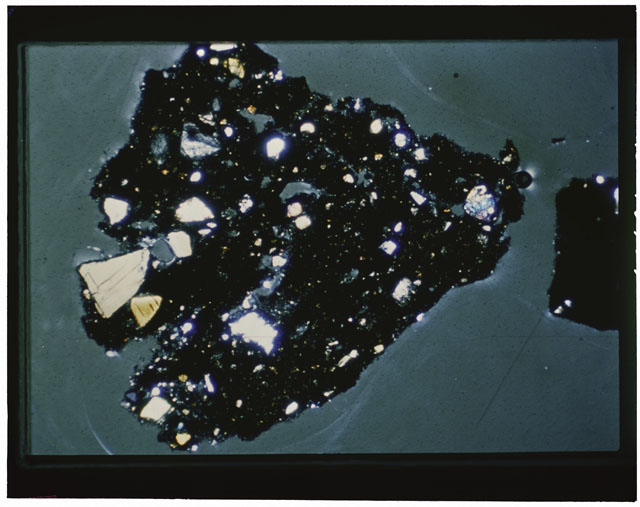 Color photograph of Apollo 12 sample 12033,82; Thin Section photograph displaying grain mount using cross nichols light.