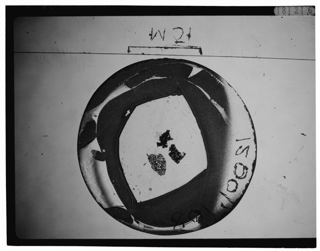 Black and white photograph of Apollo 12 sample 12001,108; Thin Section photograph displaying grain mount.