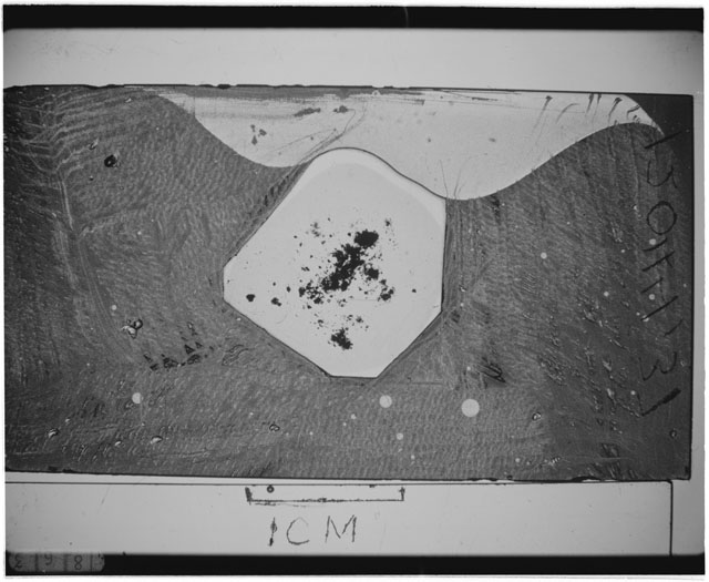 Black and white photograph of Apollo 12 sample 12044,37; Thin Section photograph displaying grain mount.