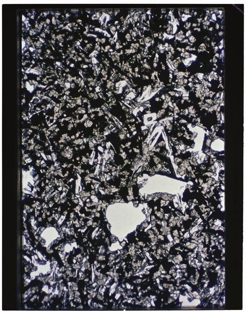 Color photograph of Apollo 11 Sample(s) 10057; Thin Section B photograph using transmitted light.