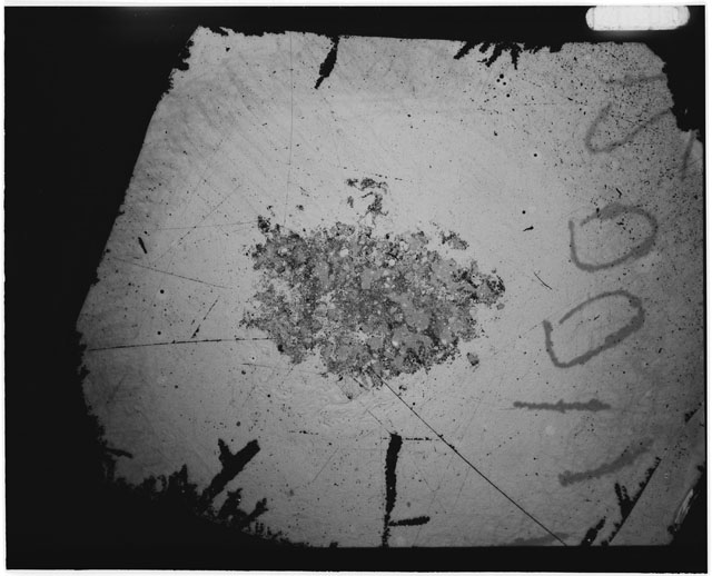 Black and white photograph of Apollo 12 sample 12001,113; Thin Section photograph displaying grain mount.