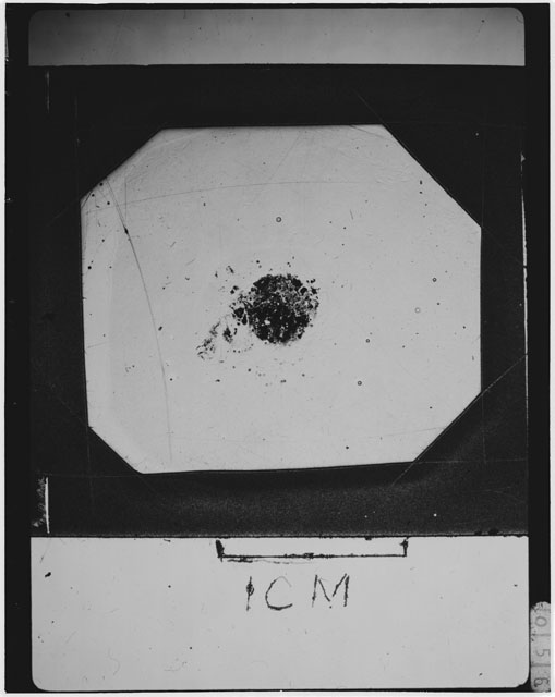 Black and white photograph of Apollo 12 sample 12033,87; Thin Section photograph displaying grain mount.