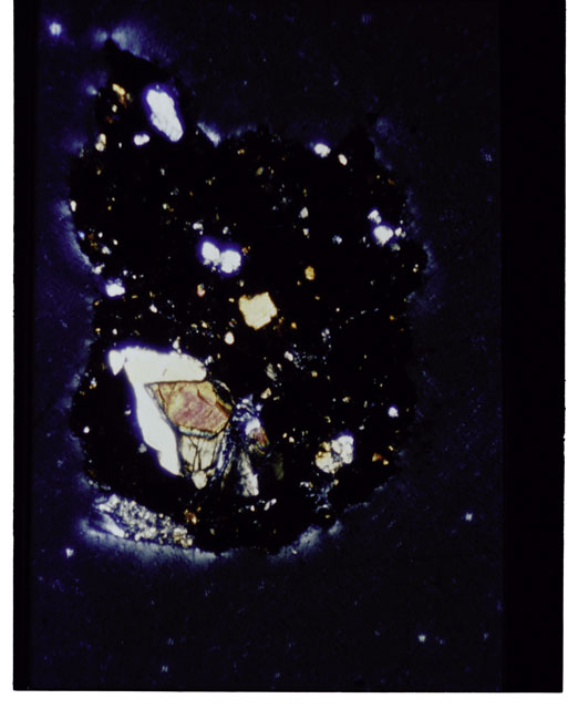 Color photograph of Apollo 12 sample 12070,162; Thin Section photograph displaying grain mount using cross nichols light.