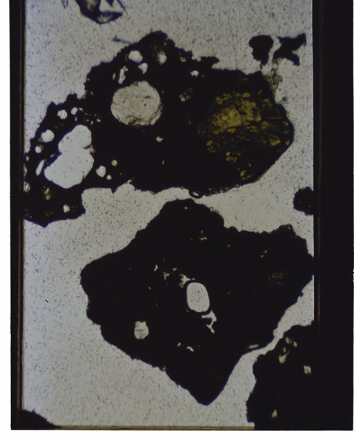 Color photograph of Apollo 12 sample 12070,162; Thin Section photograph displaying grain mount using transmitted light.