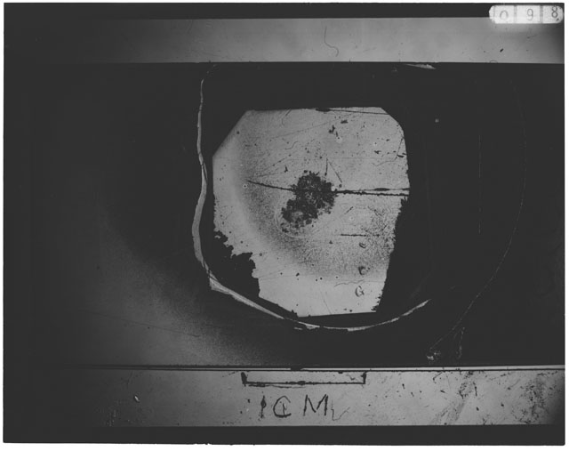 Black and white photograph of Apollo 12 sample 12033,89; Thin Section photograph displaying grain mount.