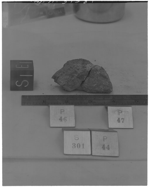 Black and white photograph of Apollo 14 Sample(s) 14301,44,46,47; Processing photograph displaying a reconstruction with an orientation of E,S .