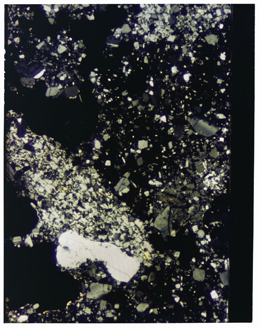 Color photograph of Apollo 16 Sample(s) 65015; 2.5x magnification of a Thin Section photograph using cross nichols light.