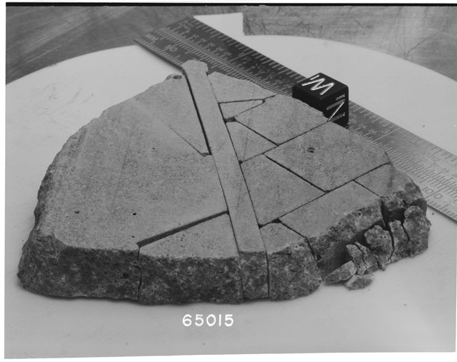 Black and white photograph of Apollo 16 Sample(s) 65015; Processing photograph displaying slab reconstruction with an orientation of W,N.