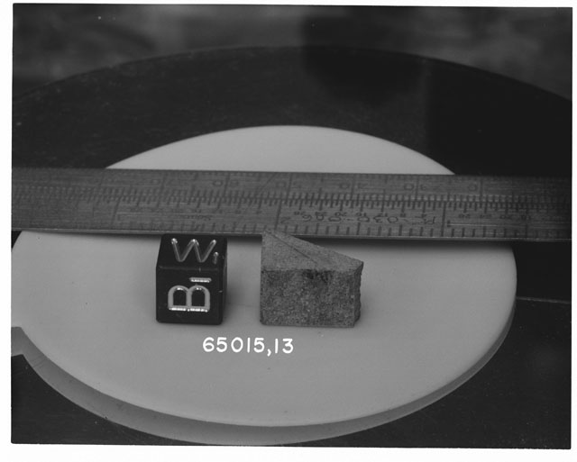Black and white photograph of Apollo 16 Sample(s) 65015,42; Processing photograph displaying slab with an orientation of W,B.