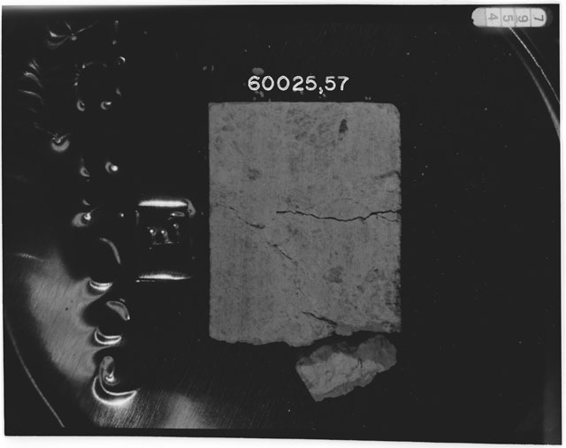 Black and white photograph of Apollo 16 Sample(s) 60025,57; Processing photograph displaying chip.