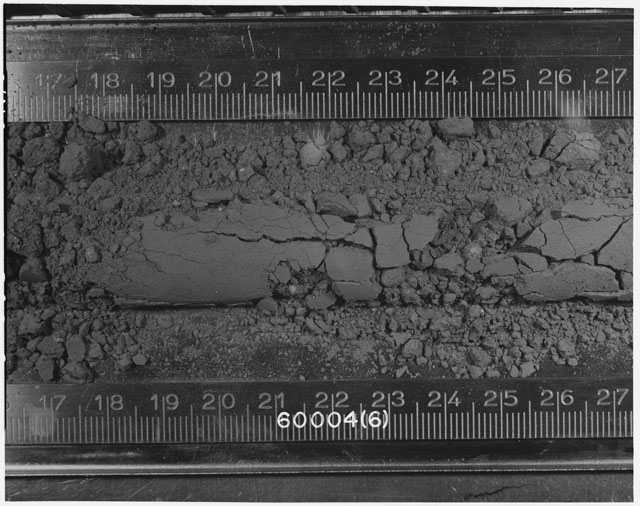 Black and white photograph of Apollo 16 Sample(s) 60004; 6 of 10 Processing photograph displaying Core Tube at 16.5-27.5 cm depth.