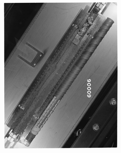 Black and white photograph of Apollo 16 Core Sample 60006; Processing photograph displaying an overview of the Core Tube with drill stem.