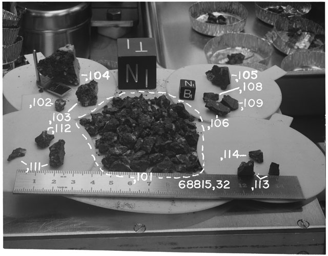 Black and white photograph of Apollo 16 Sample(s) 68815,32,101-106,108,109,111-114; Processing photograph displaying group with an orientation of T,N.