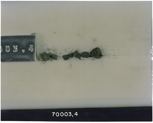 Color photograph of Apollo 17 Sample(s) 70003,4; Processing photograph displaying a group of >17 M Core Fines found at 211.7-212.4 cm depth from surface.