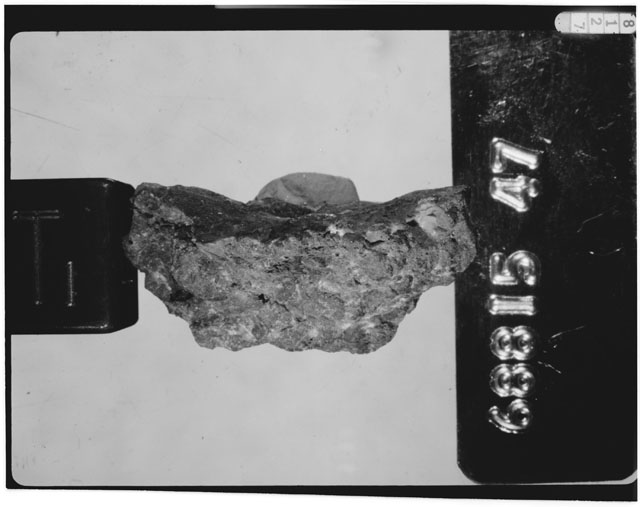 Black and white photograph of Apollo 16 Sample(s) 68815,47; Processing photograph displaying a chip using reflected light.